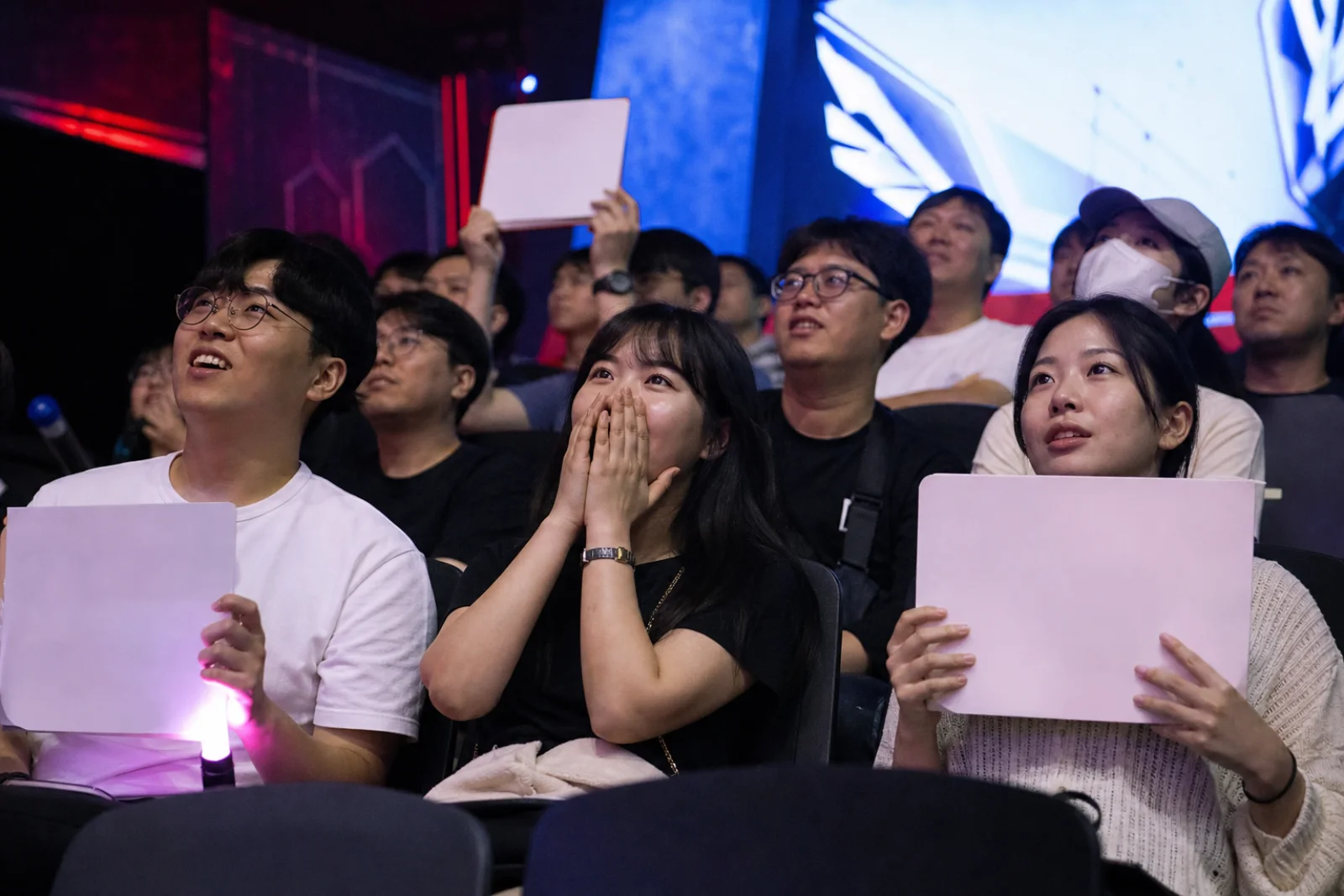A fictional esports audience reacting together in a compact live studio