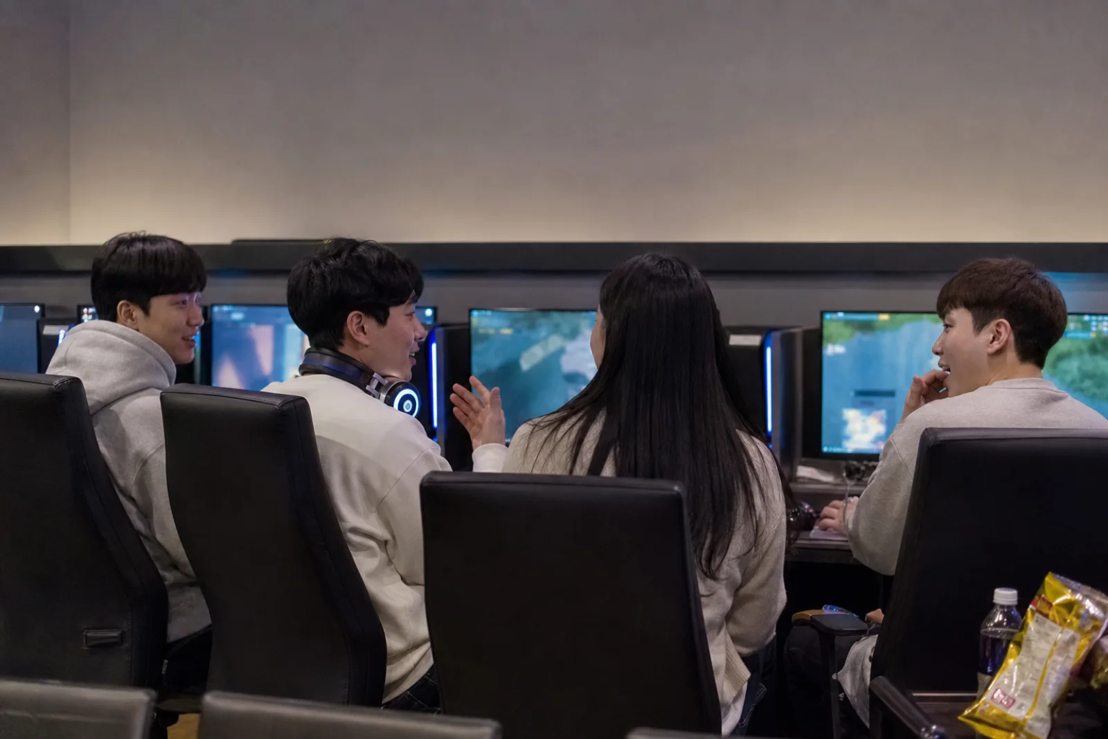 Friends gaming together at a clean neighborhood PC bang without visible game titles