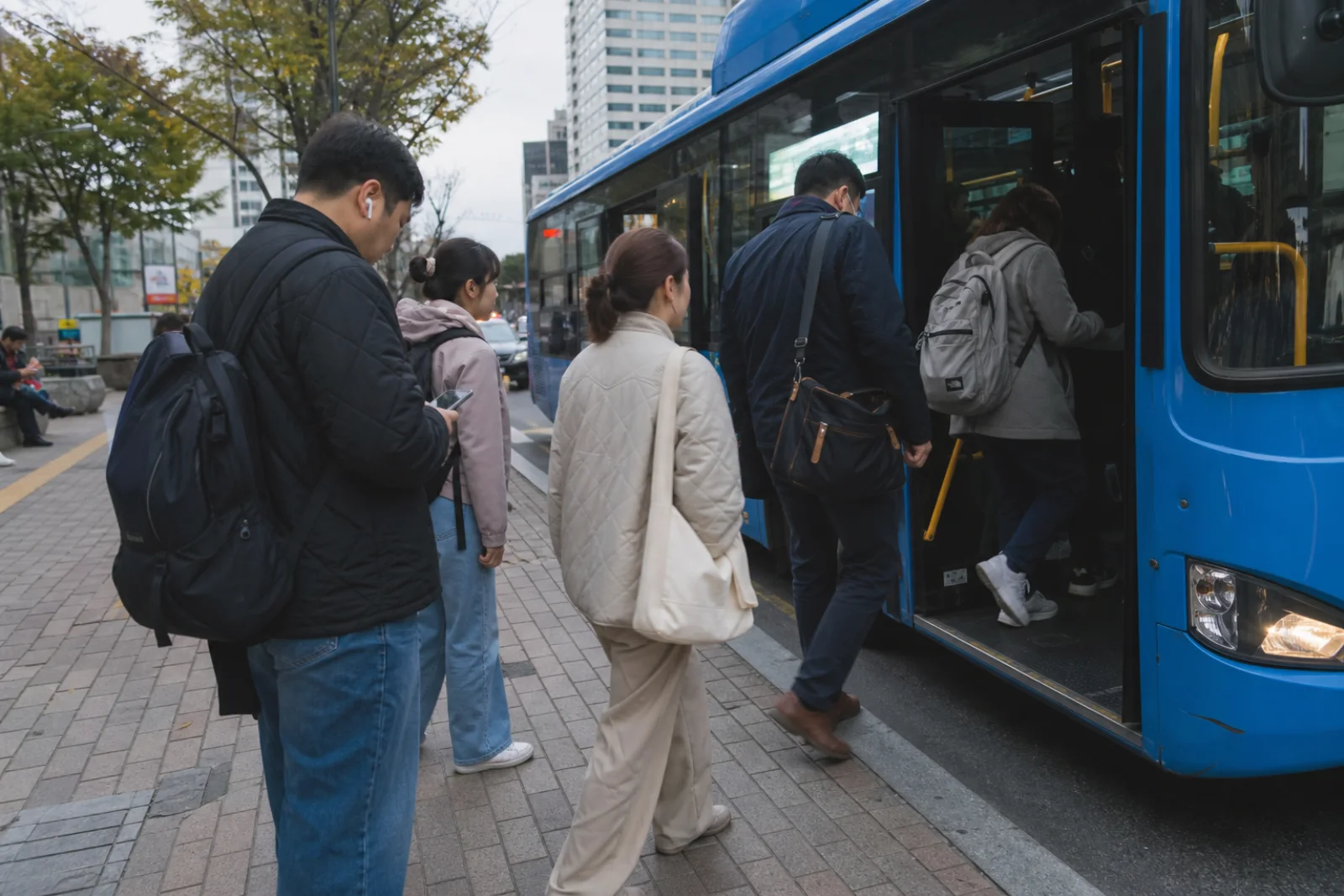 Commuters boarding a clean Seoul city bus in soft afternoon light