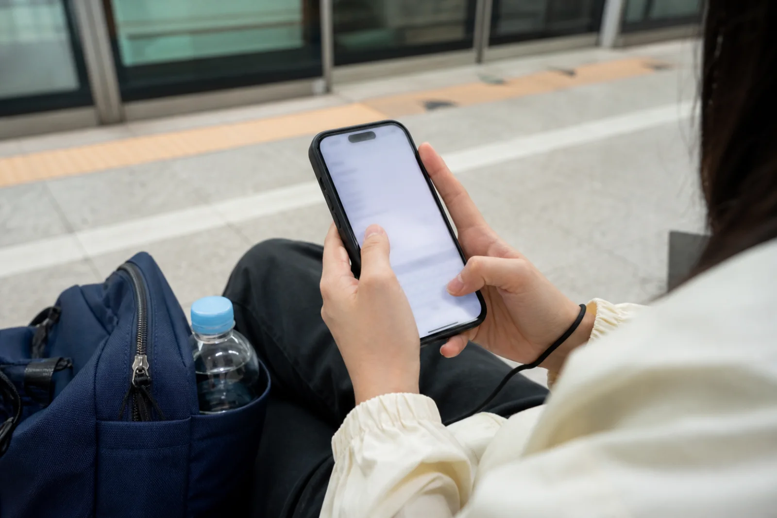 A traveler saving emergency information on a phone at a quiet Seoul station