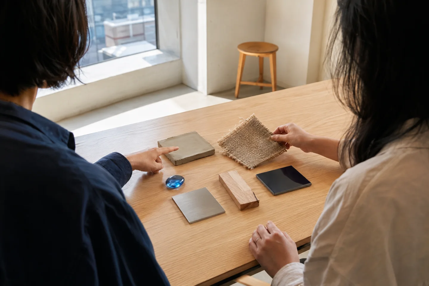AI-generated editorial view of two anonymous adults comparing generic glass, clay, fiber, wood, metal, and lacquer material samples at an unbranded museum education table