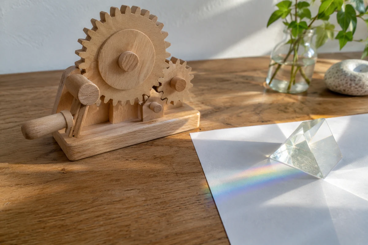 Conceptual gear model and prism on a science-learning desk