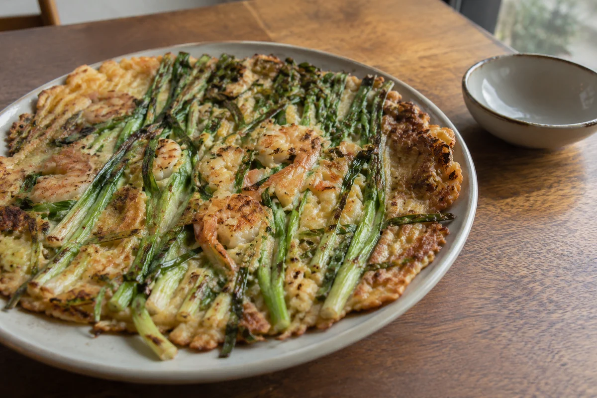 Illustrated thick scallion seafood pancake with a golden tender center